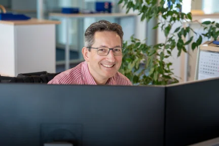Ein Kollege an seinem Arbeitsplatz im Büro