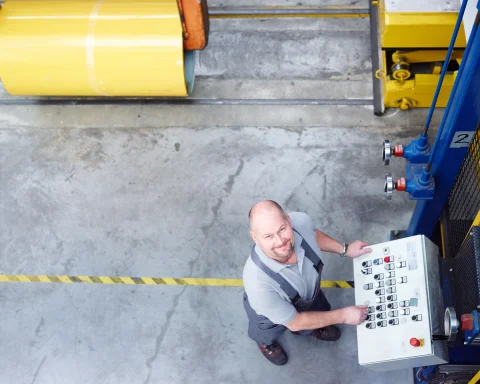 Ein ROMA Mitarbeiter bedient eine Maschine in der Produktion
