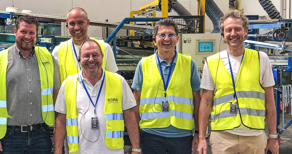 Fünf Besucher in Warnwesten bei einer Werksführung