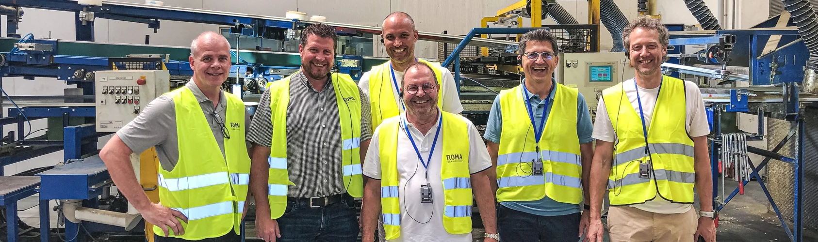 Fünf Besucher in Warnwesten bei einer Werksführung